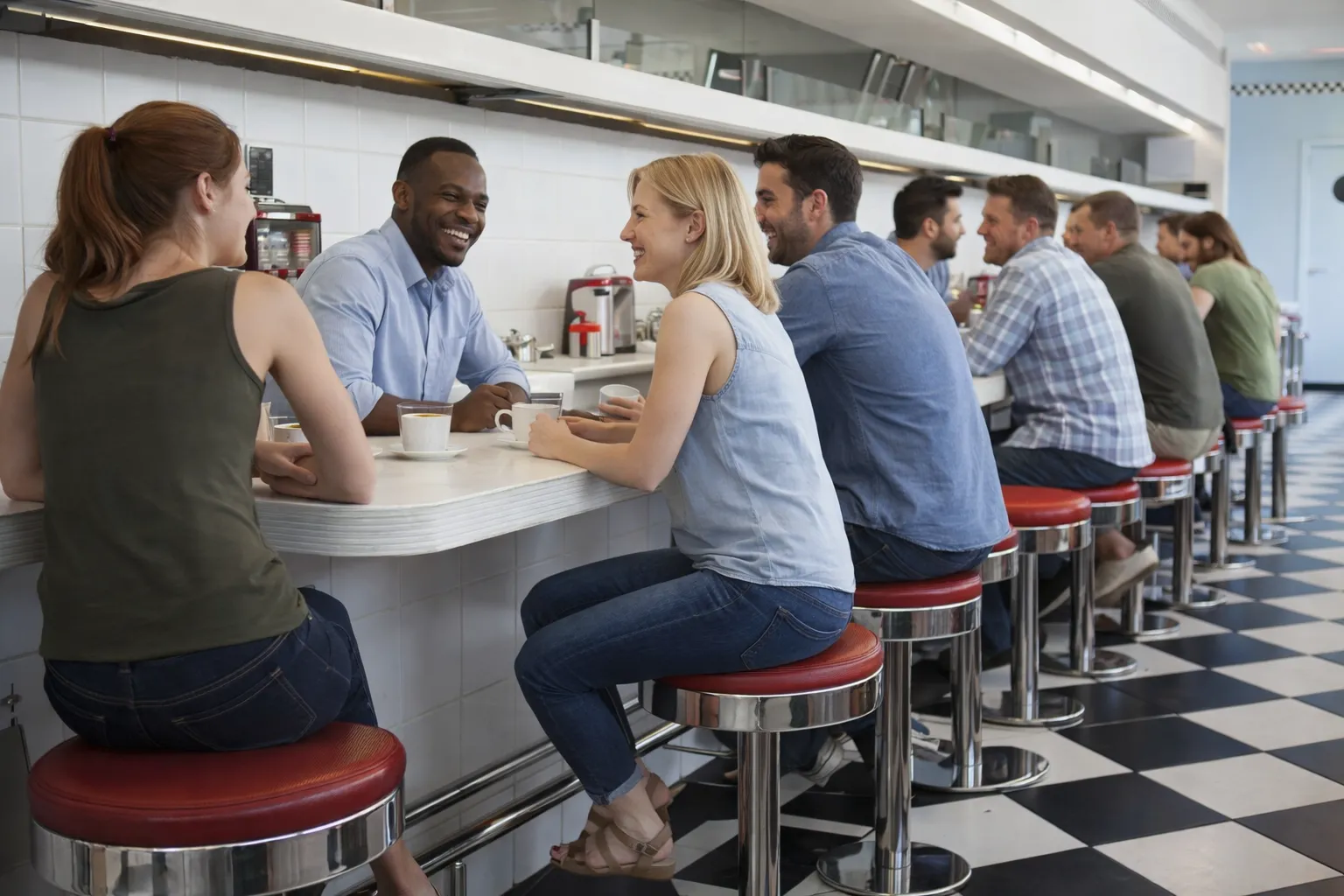 People talking together at a diner lunch counter